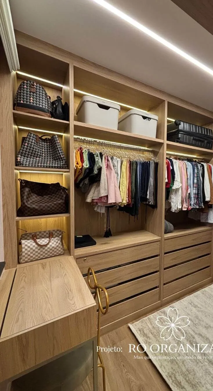 Closet de madeira com bolsas, roupas e gavetas organizadas em um projeto da Ro Organiza
